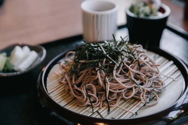 Photo soba noodles with soup on wood background