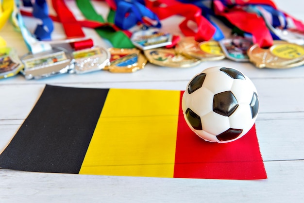 Soccer ball and Belgian flag medals blurred in the background