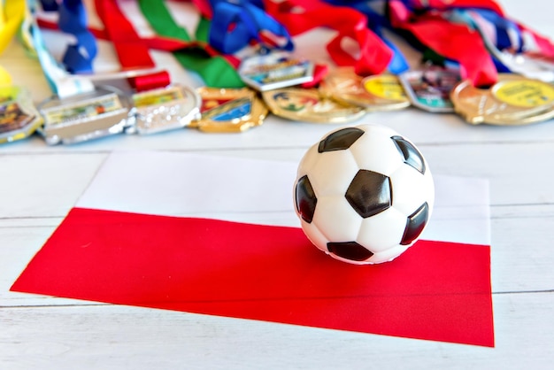 Soccer ball and Polish flag medals blurred in the background