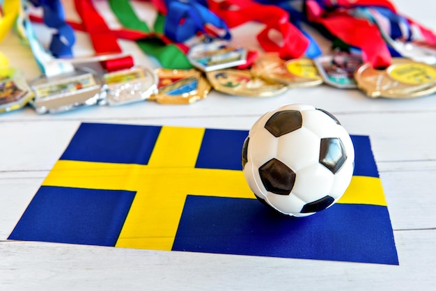 Soccer ball and Swedish flag medals blurred in the background