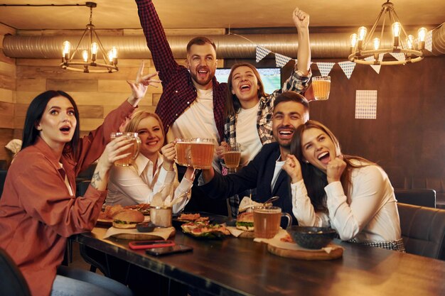 Soccer fans Group of young friends sitting together in bar with beer