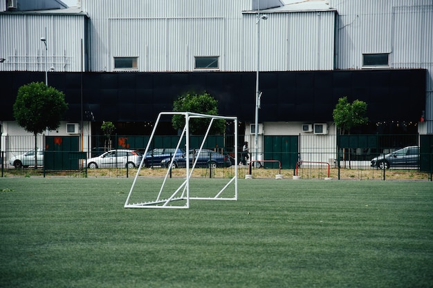 a soccer field with a soccer goal and a building behind it