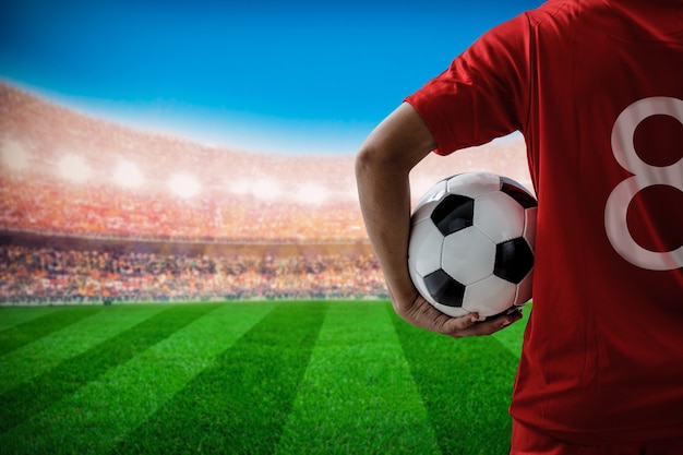 soccer football player no.8 in red team concept holding soccer ball in the stadium