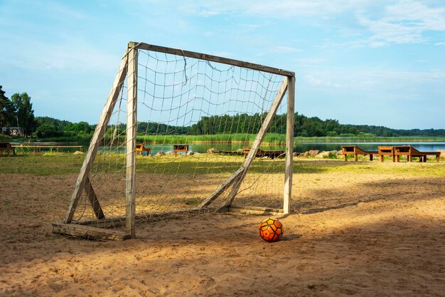 Soccer goal and ball on the beach Sunlight water and sand The beach on the lake