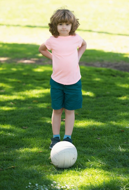 Photo soccer kid kids play football on outdoor stadium field little boy kicking ball school football sports club training for sport children child soccer football