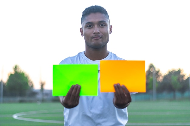 Soccer referee taking out two cards on the field Front view of soccer referee taking out cards