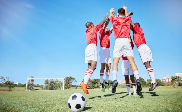 Soccer sports and motivation with a team jumping on a grass pitch or field during training or practice Fitness football and exercise with an athlete group celebrating together during a workout