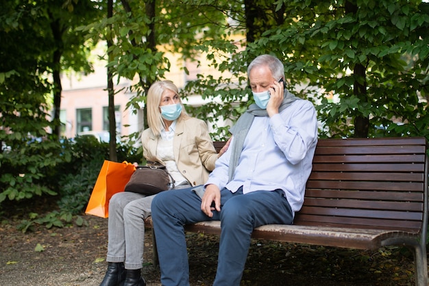 Social distancing and separation concept, coronavirus prevention while sitting on a bench in a park concept