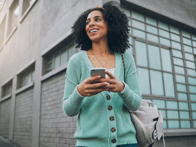 Social media city and woman with a phone for gps location internet and mobile app in a street Happy young and African girl with a smartphone for the web online chat and communication on tech