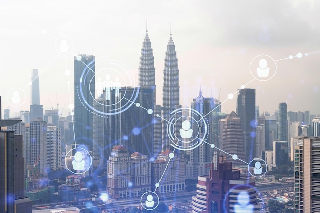 Social media icons hologram over panorama city view of Kuala Lumpur Malaysia Asia The concept of people networking connections and career opportunities Double exposure