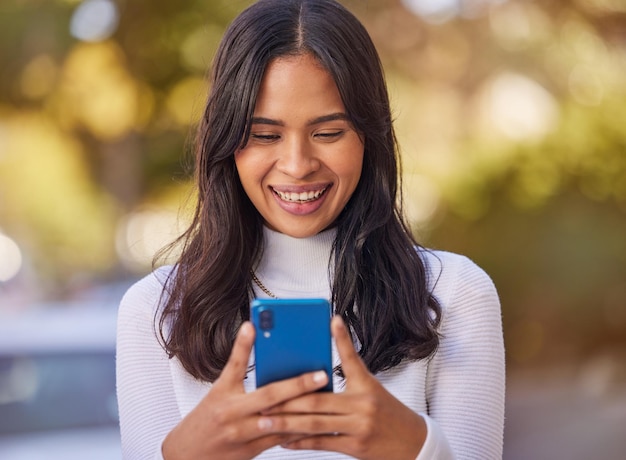 Social media phone and woman in the city for business working and reading communication on a mobile Happy smile and young girl typing on a mobile app with 5g technology on the web in the street