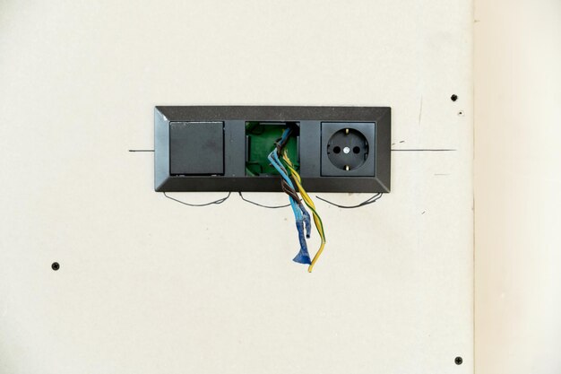 Socket repair on a white background electrical wires sticking out of the outlet