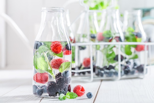 Soda in bottle with berries on white table