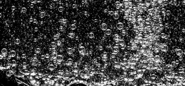 Photo soda water bubbles splashing underwater against black background