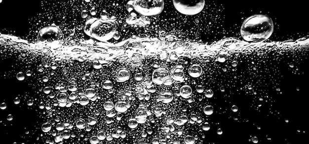 Photo soda water bubbles splashing underwater against black background