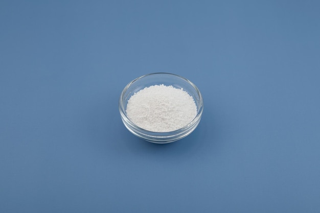 Sodium benzoate sodium salt of benzoic acid in glass dish on blue background Food additive E211