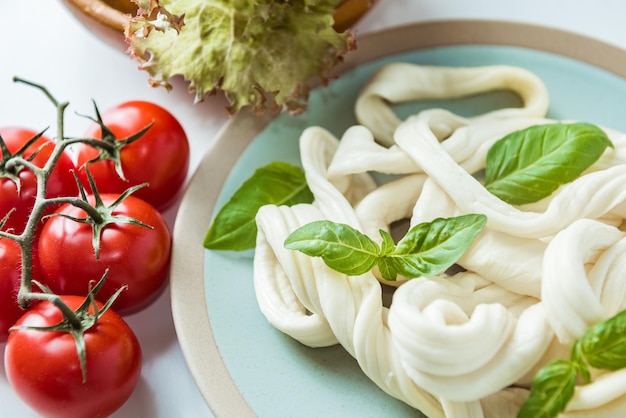 Soft cecil cheese with basil leaves and fresh tomatoes