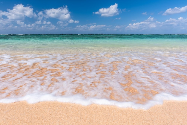 Soft crystal clear wave of blue ocean on sandy beach Selective focus