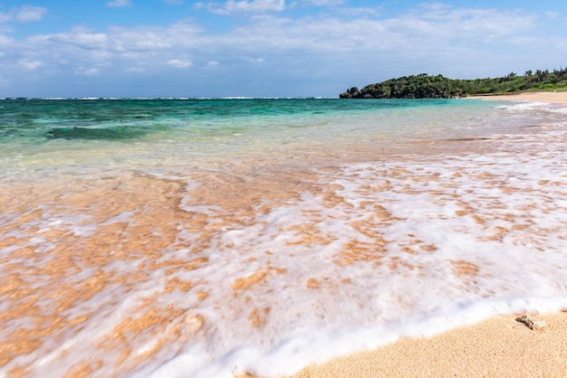 Soft crystal clear wave breaking along the seashore white foam Selective focus