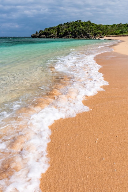 Soft crystal clear wave breaking along the seashore white foam Selective focus