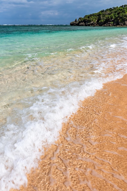 Soft crystal clear wave breaking along the seashore white foam Selective focus