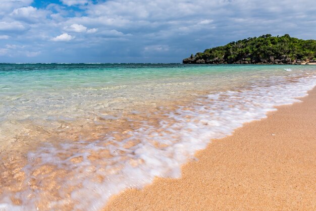 Soft crystal clear wave breaking along the seashore white foam Selective focus