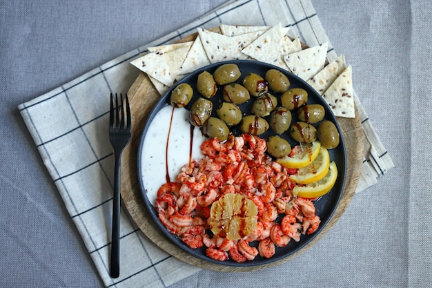 Soft focus Plate with boiled shrimps with olives lemon and sauce Healthy snack Italian food