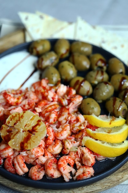 Soft focus Plate with boiled shrimps with olives lemon and sauce Healthy snack Italian food