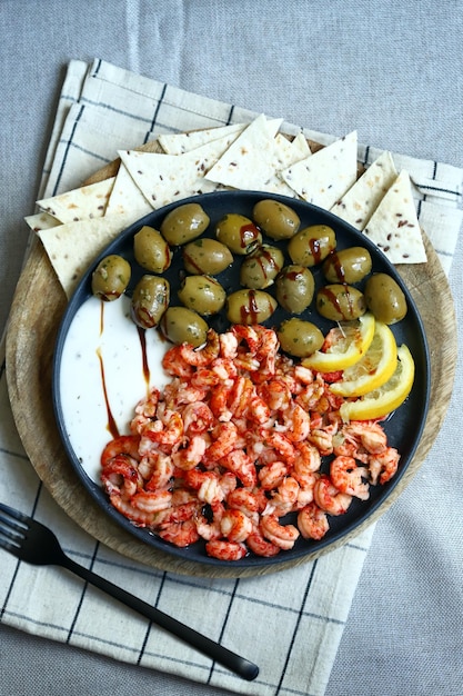 Soft focus Plate with boiled shrimps with olives lemon and sauce Healthy snack Italian food