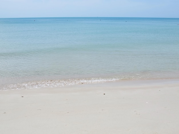 Soft focus of the waves beat at the beach with sand and blue sky with reflection in summer