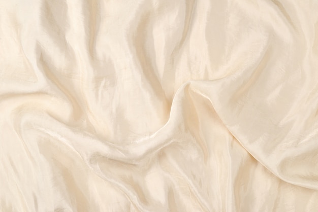 Soft smooth beige silk fabric background. Fabric texture.