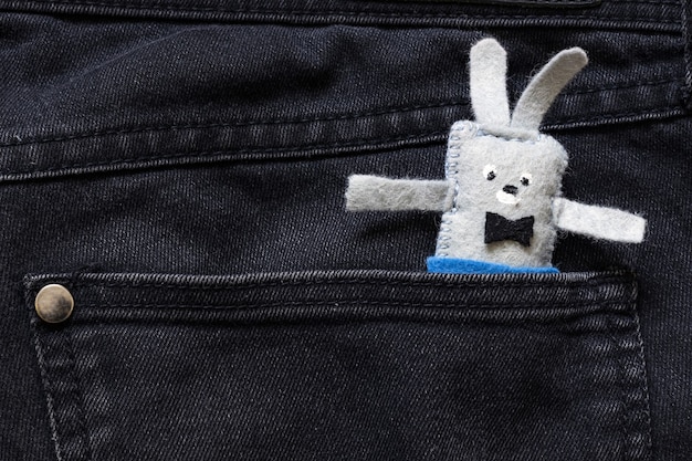 Soft toy hare sticks out of a jeans pants pocket