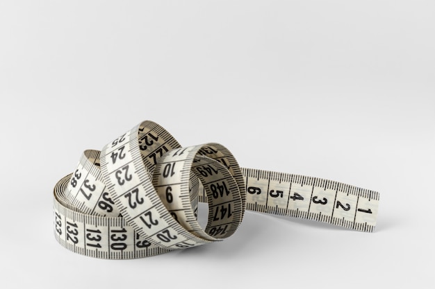 Soft two sided tape measure roll isolated on a white and gray background with copy space