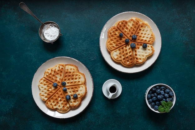 Soft Viennese waffles with blueberries, chocolate sauce and icing sugar