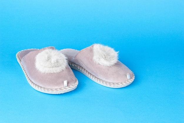 Soft warm slippers on a blue background