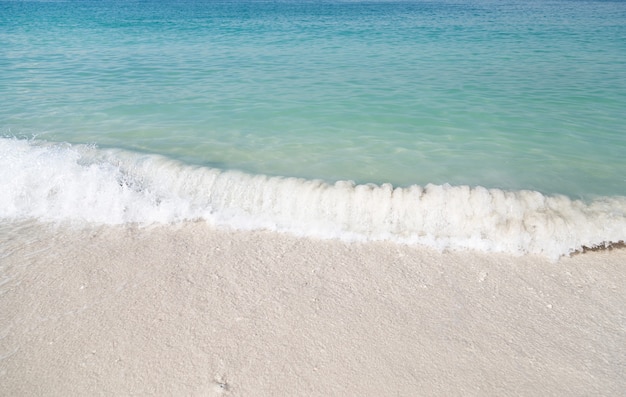 Soft wave of blue ocean on sandy beach. Background.