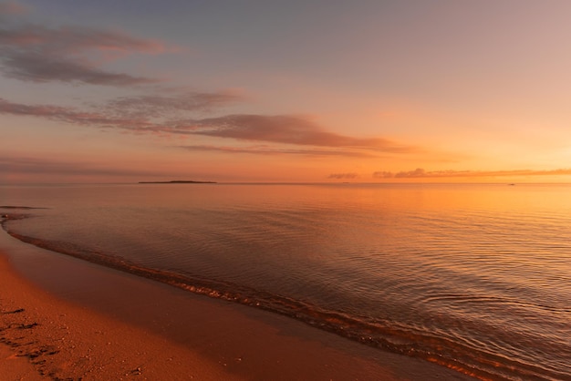 Soft wave of morning ocean on sandy beach Tranquil sunrise concept