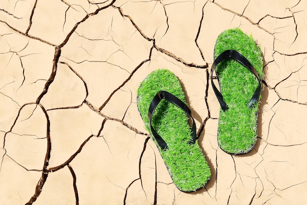 Soil erosion green slippers with grass immitation concept of drought environmental problems