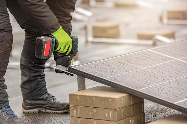 The solar panel installer twists the modules together using aluminum fasteners and a cordless drill