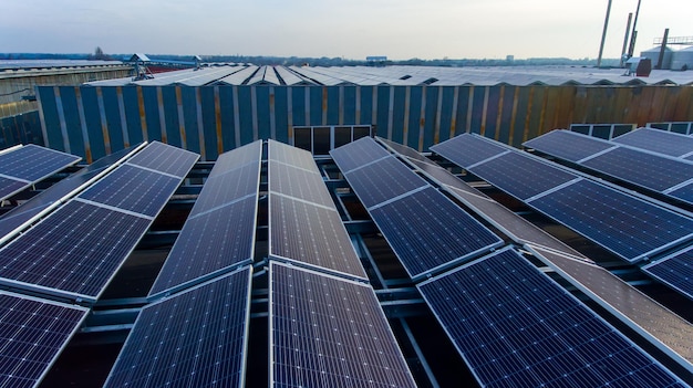 Solar panel modules on the plant roof Engineers walking between the rows of solar cells Blue skies over the blue solar cells