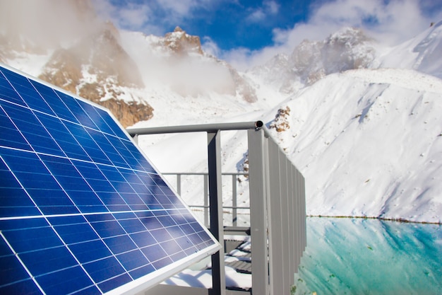 Solar panel in mountain lake on blue sky background. Alternative energy concept.