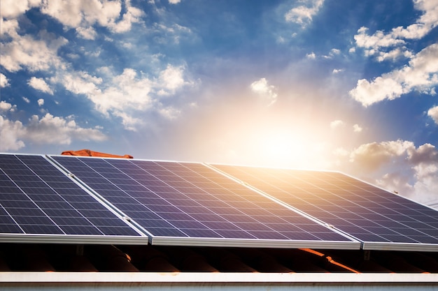 Solar panels on the red roof in a sunny and cloudy day. Photovoltaic instalation image.