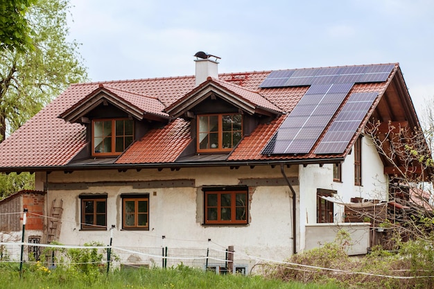 Solar panels on roof of country house Old house with solar station on tiling roof