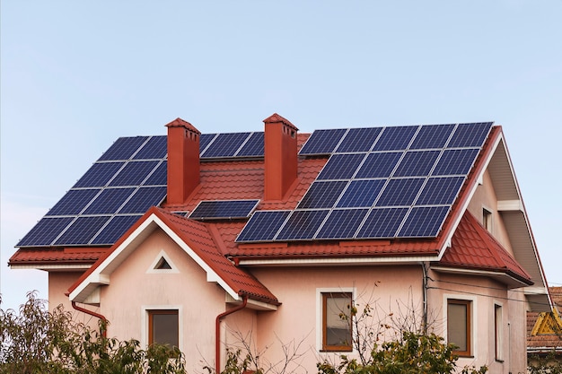 Solar panels on the roof of private house are installed around the chimney Alternative energy