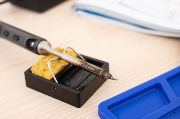 Soldering iron on a stand on the desktop