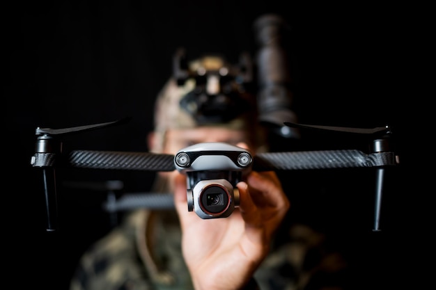 Photo a soldier drone pilot holds a quadcopter with a camera in his hand