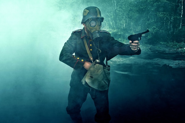 Soldier in a gas mask aims his gun.