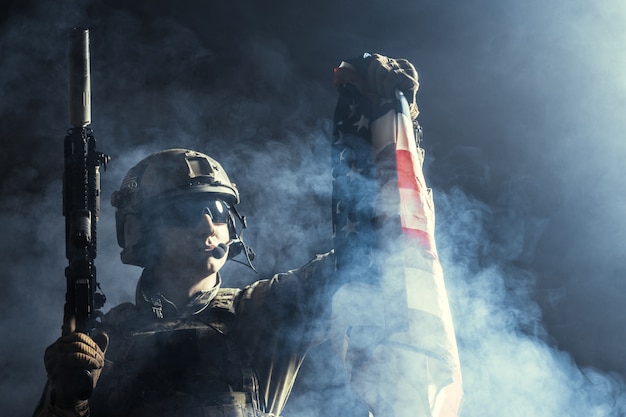 Soldier holding machine gun with national flag