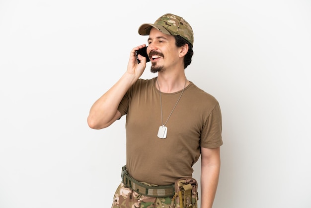 Soldier man isolated on white background keeping a conversation with the mobile phone