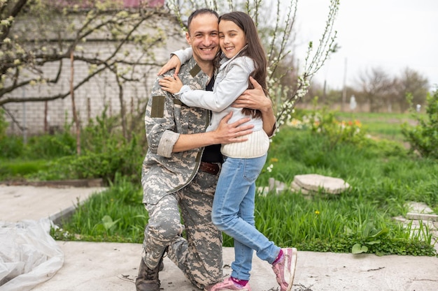 Soldier reunited with his daughter on a sunny day.